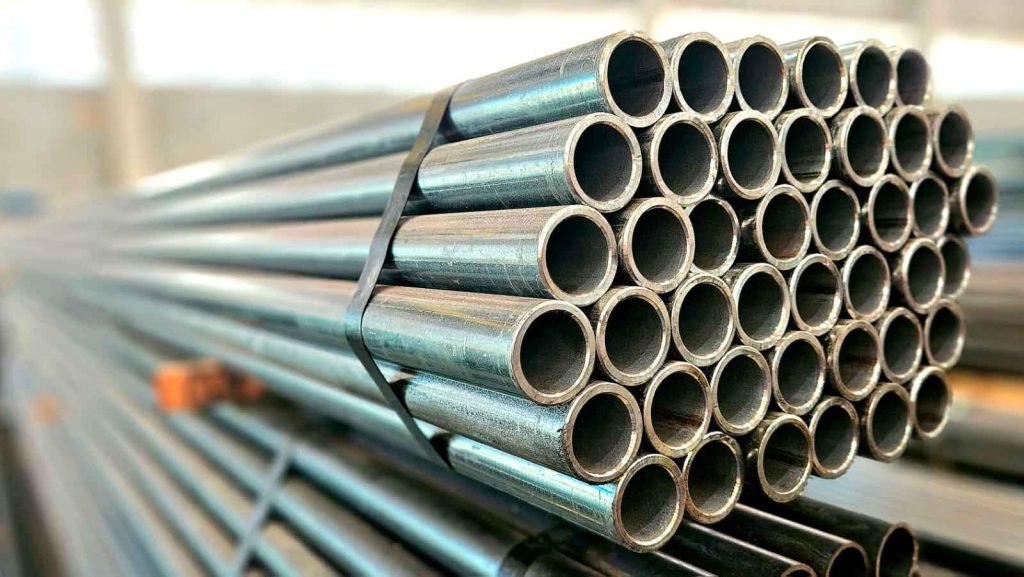 Estoque de tubos condutores de aço carbono redondos, amarrados e empilhados, prontos para uso em projetos de infraestrutura.