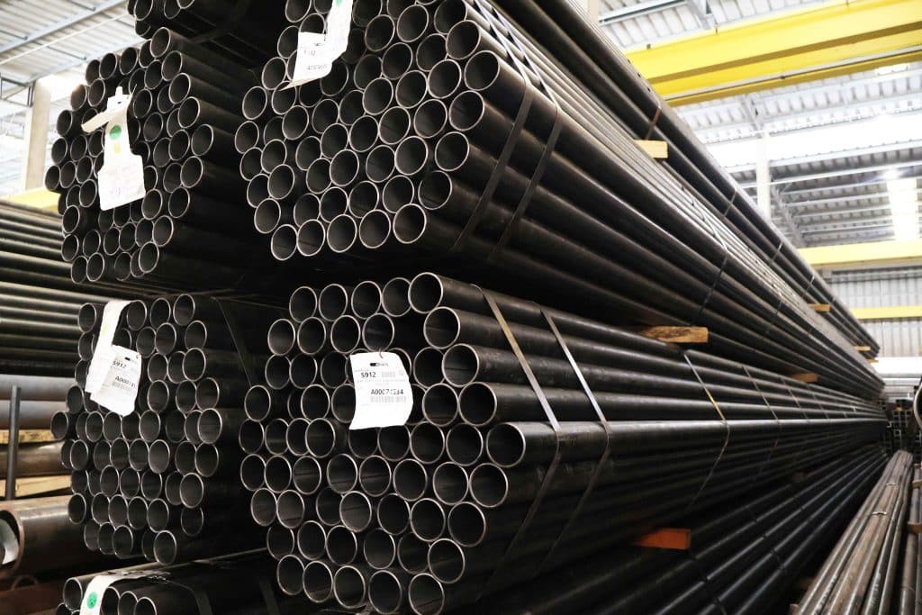 Grande estoque de tubo para caldeira de norma ASTM A178 em pilhas amarradas com etiquetas de identificação no depósito.