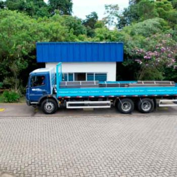 Caminhão de grande porte posicionado sobre a balança rodoviária para pesagem de carga no pátio da empresa.